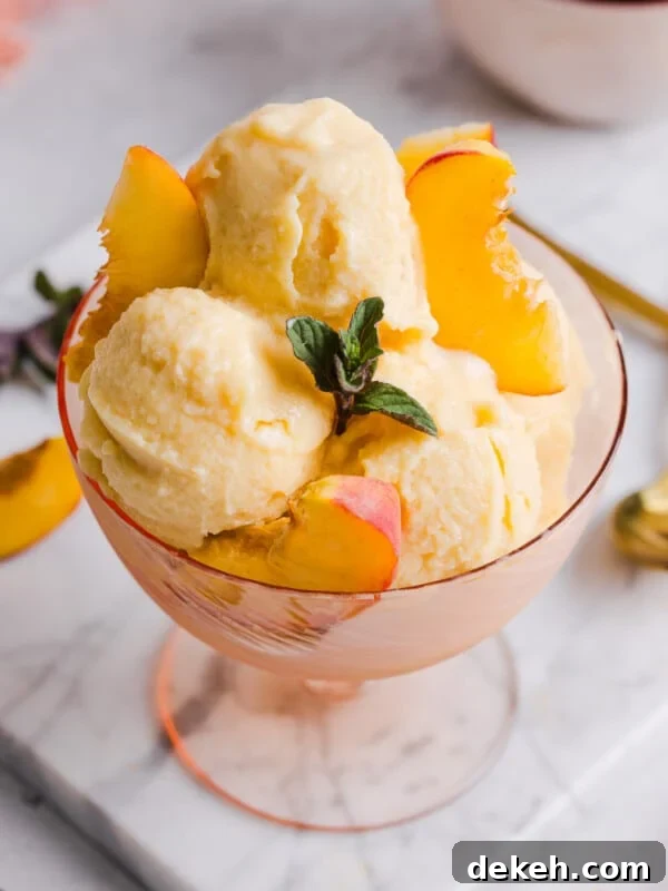 Overhead image of peach ice cream served in a bowl with peach slices.