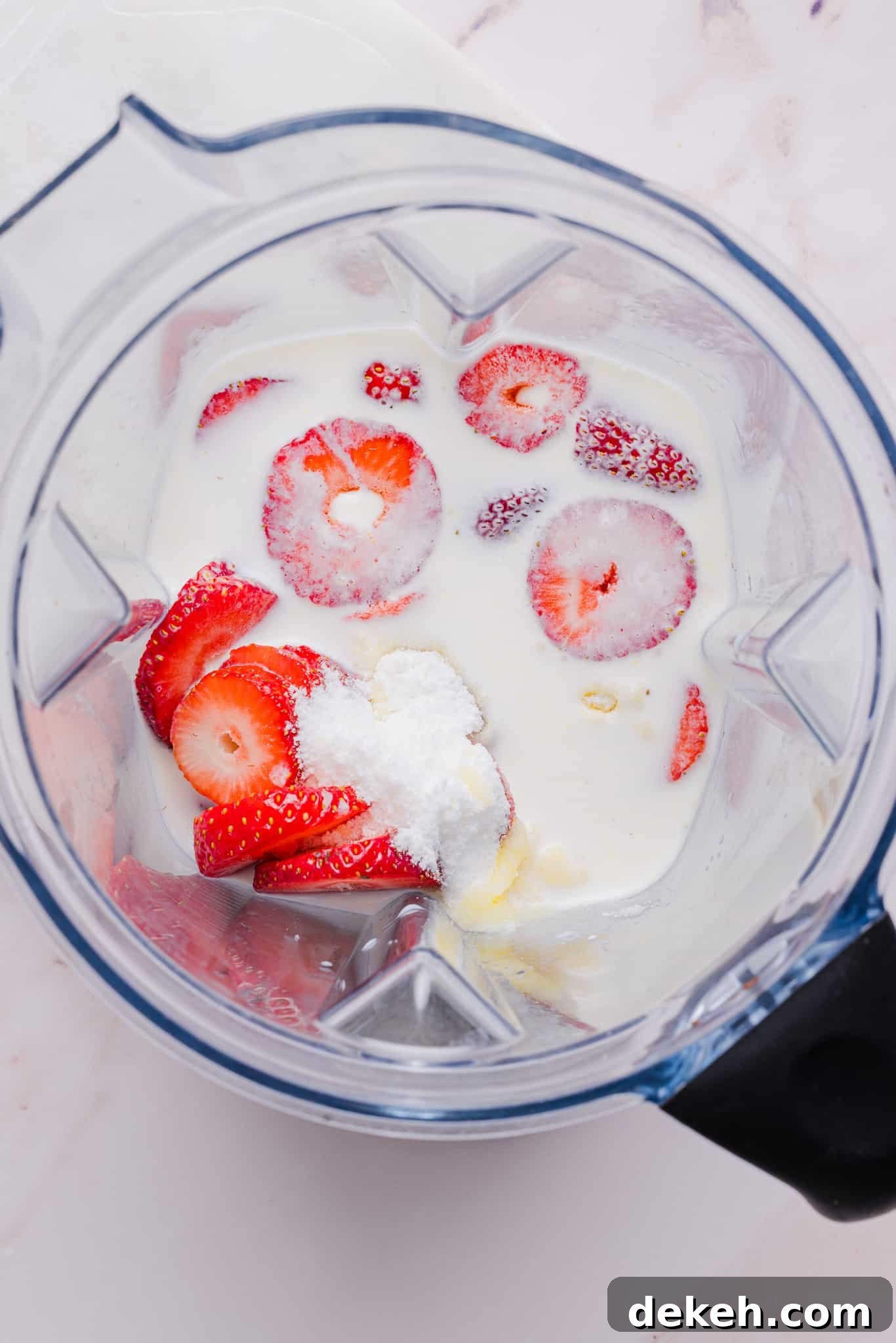 Ingredients for strawberry ice cream in a blender.
