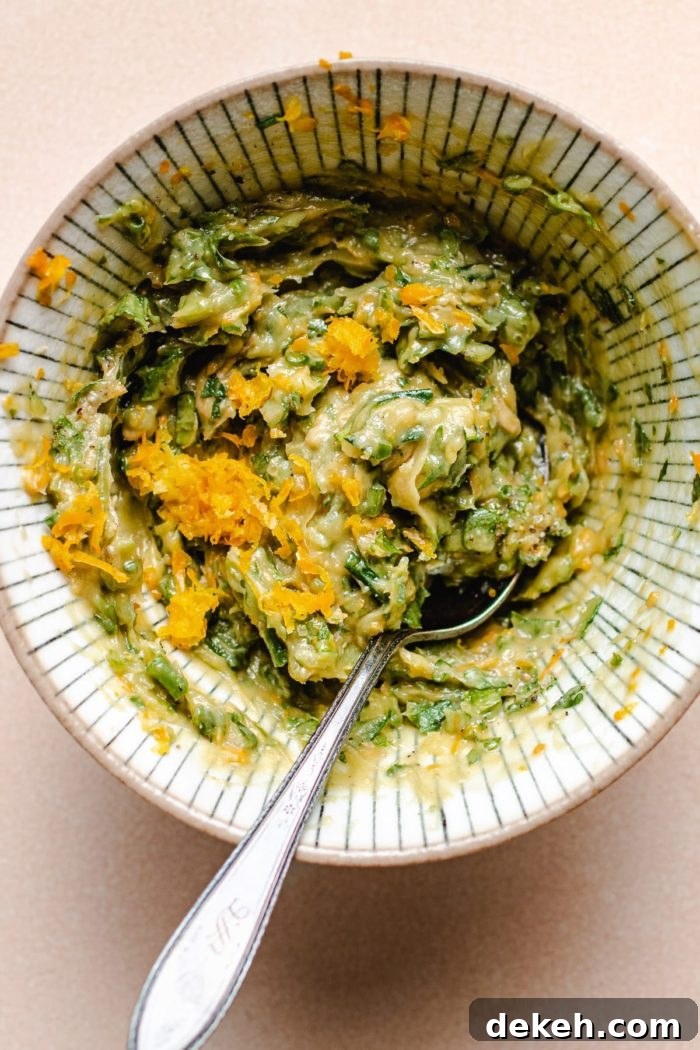 Photo shows the herb lemon butter mixed with fresh herbs in a small bowl