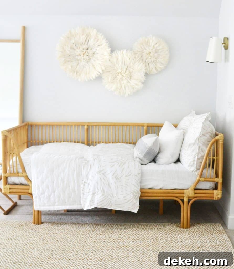 my rattan daybed with blankets and pillows on top, and juju hats above it on the wall