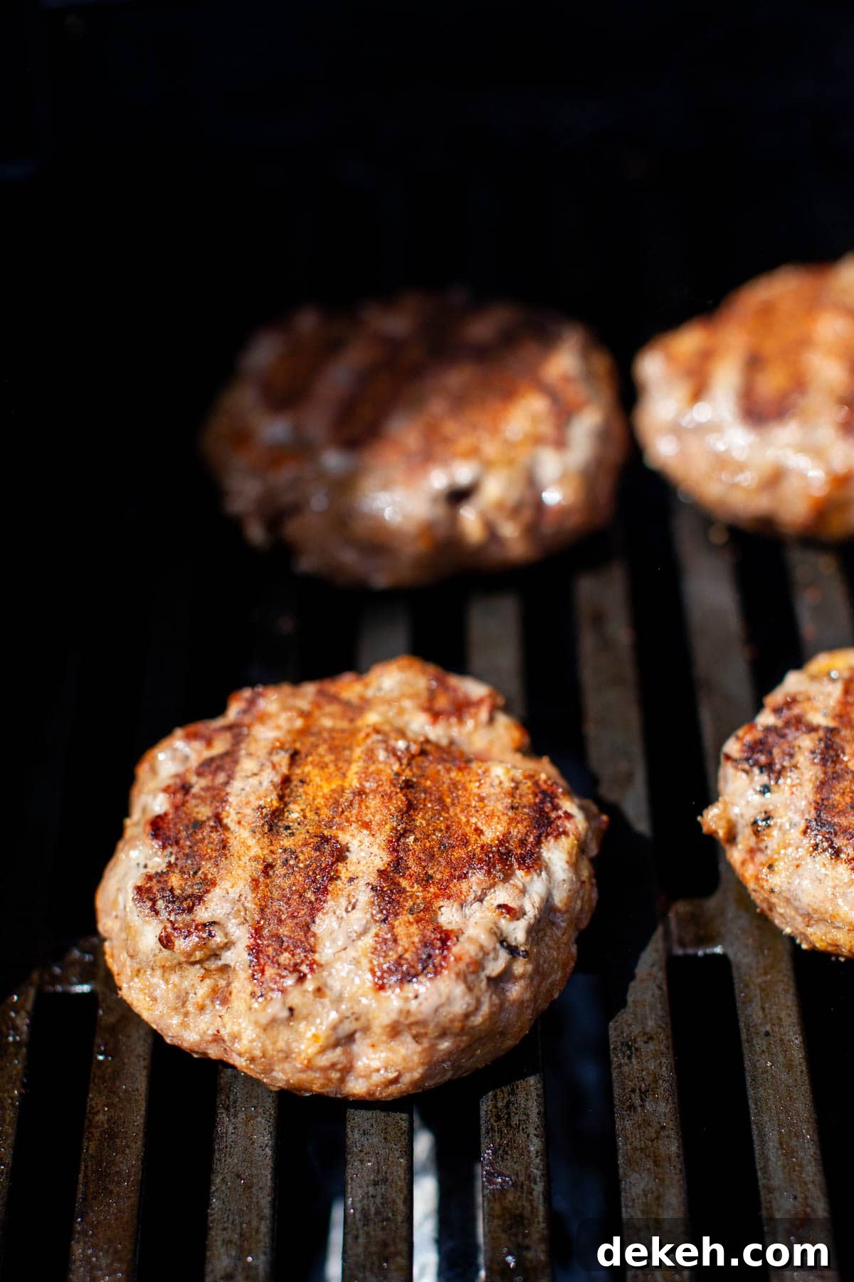Beef burgers being grilled.