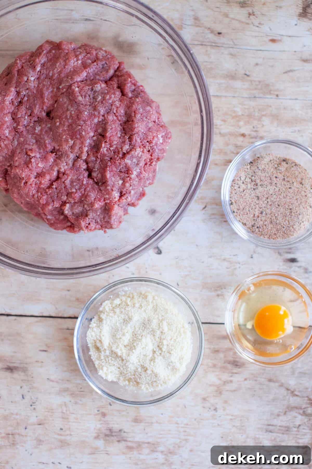 Beef burger ingredients are separated into individual small, glass mixing bowls.