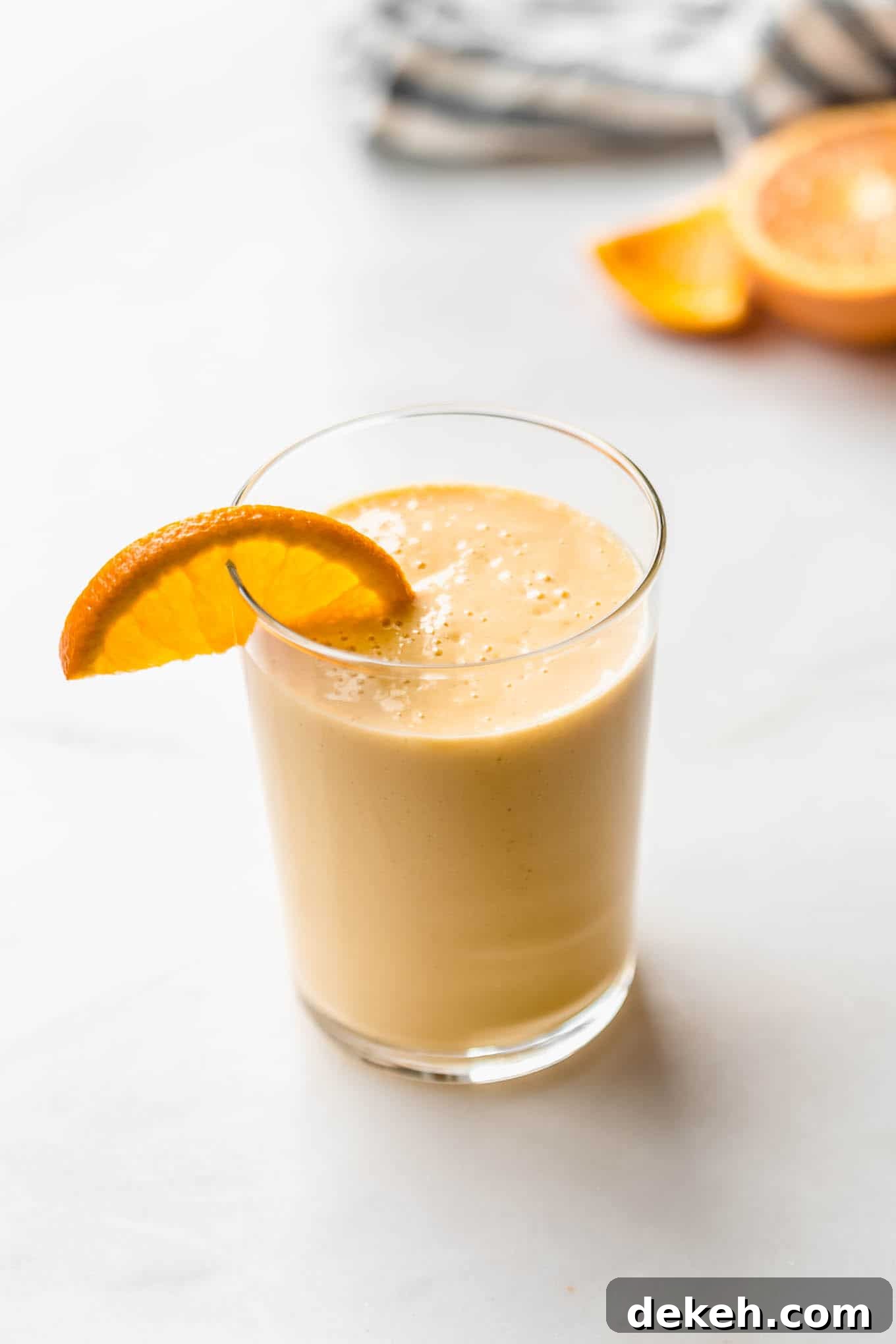 an orange creamsicle smoothie with an orange slice in it