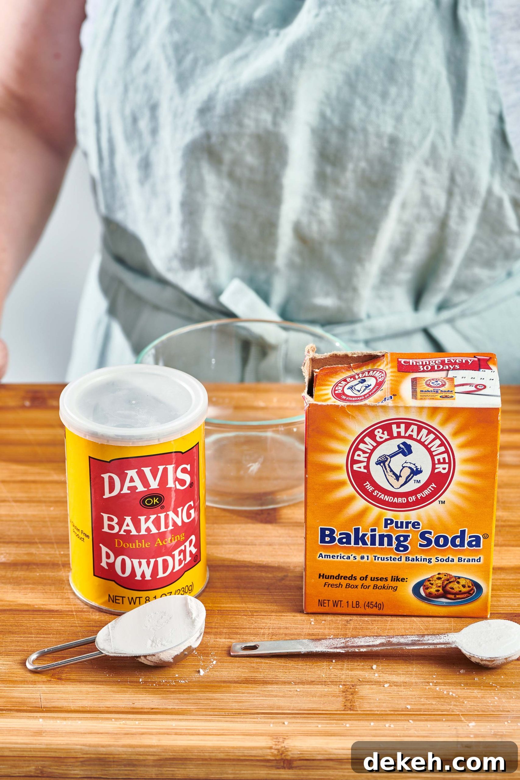 Woman standing behind packages of baking powder and baking soda on a counter.
