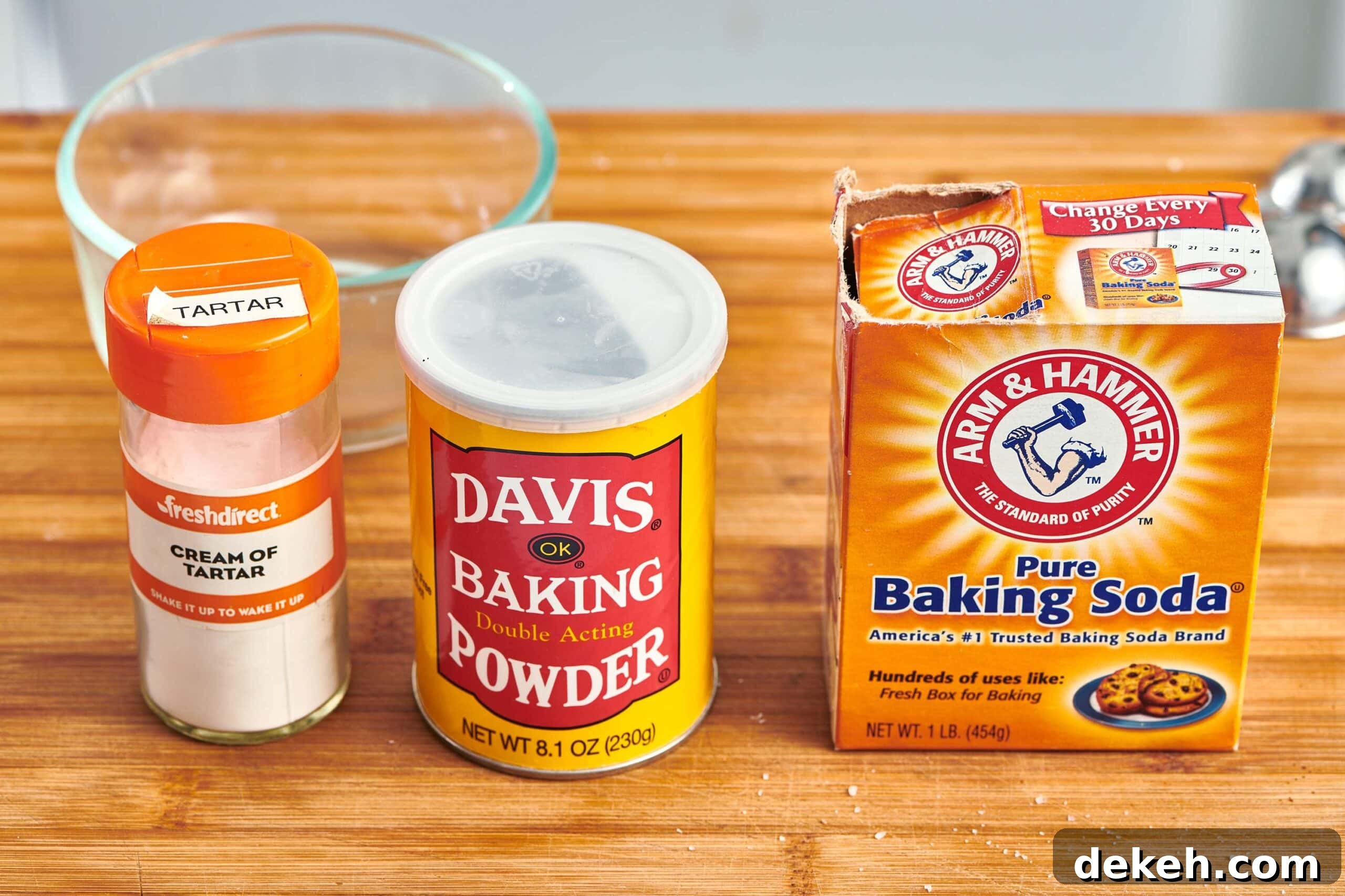 Cream of tartar, baking powder, and baking soda on a cutting board.