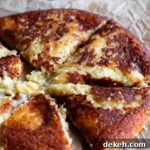 A close up of a cheesy potato cake cut into slices (frico).
