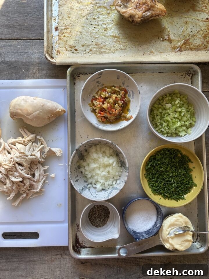 ingredients for a chicken salad in bowls on baking sheets