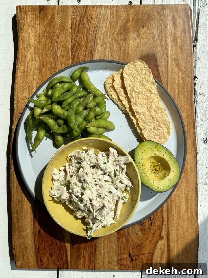 chicken salad edamame avocado parm crisps on a wooden board