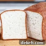 gluten free sandwich loaf on cutting board with one slice cut out of it and propped up next to it.
