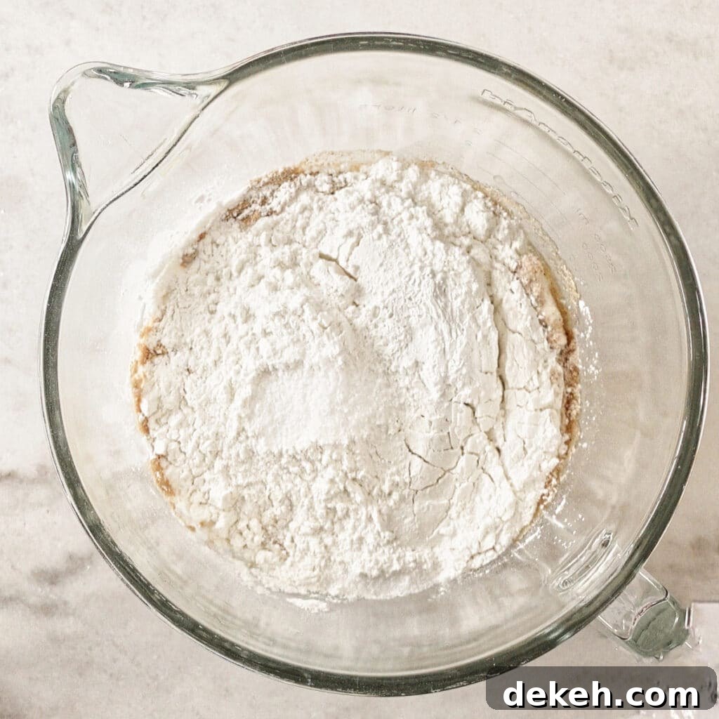 all ingredients for bread in glass mixing bowl.