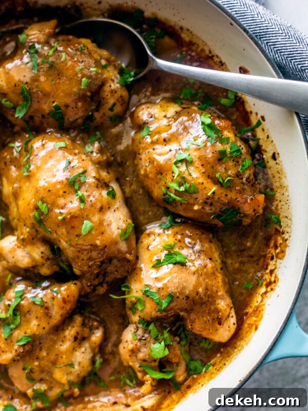 Overhead shot of saucy pan full of baked chicken thighs.