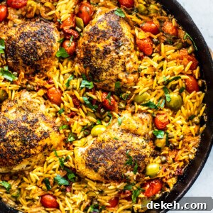 Overhead shot of skillet with orzo, crispy chicken, and veggies.
