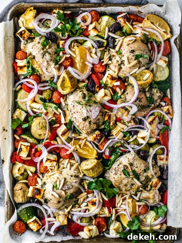 Overhead shot of sheet pan covered with roasted veggies, chicken, and feta.