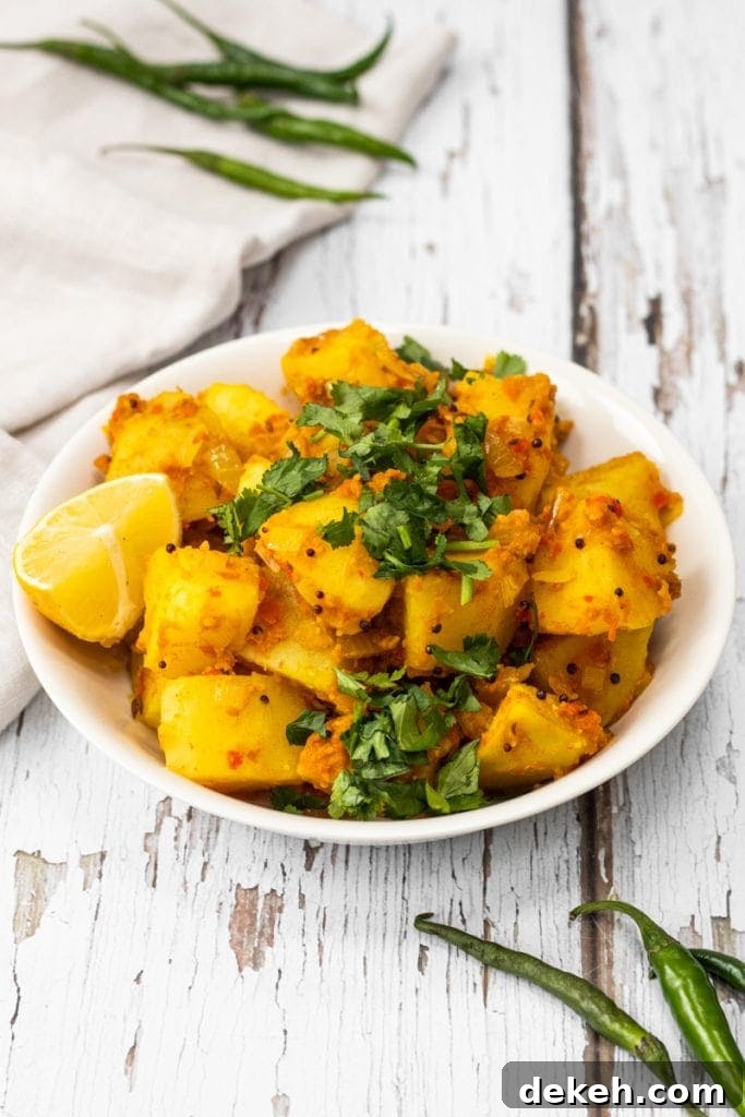 Bowl of Bombay potatoes topped with coriander