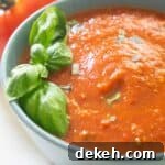 fresh tomato marinara sauce with basil leaves in grey bowl