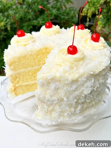 Sliced Pina Colada Cake on a glass pedestal.