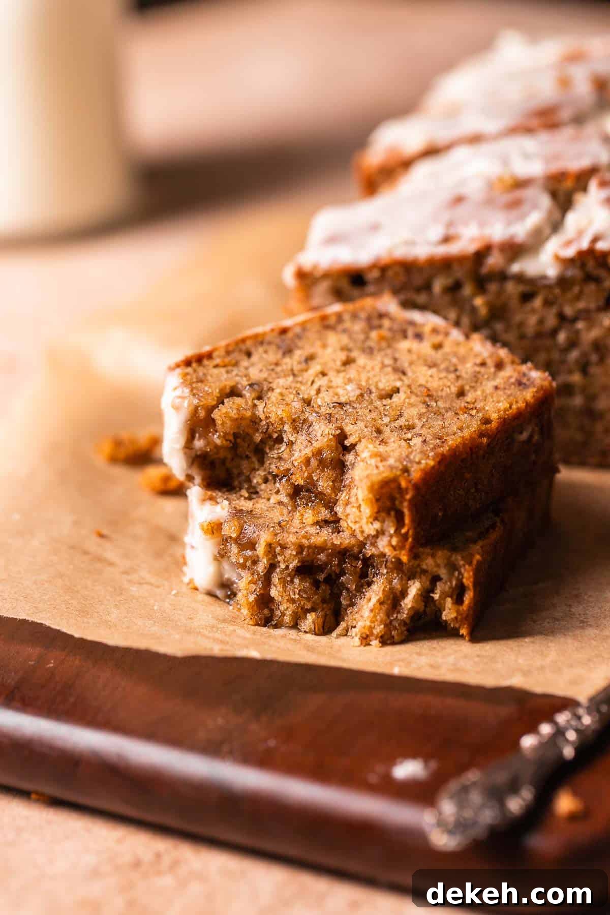 A slice of banana bread broken in half to show the moist and tender texture.