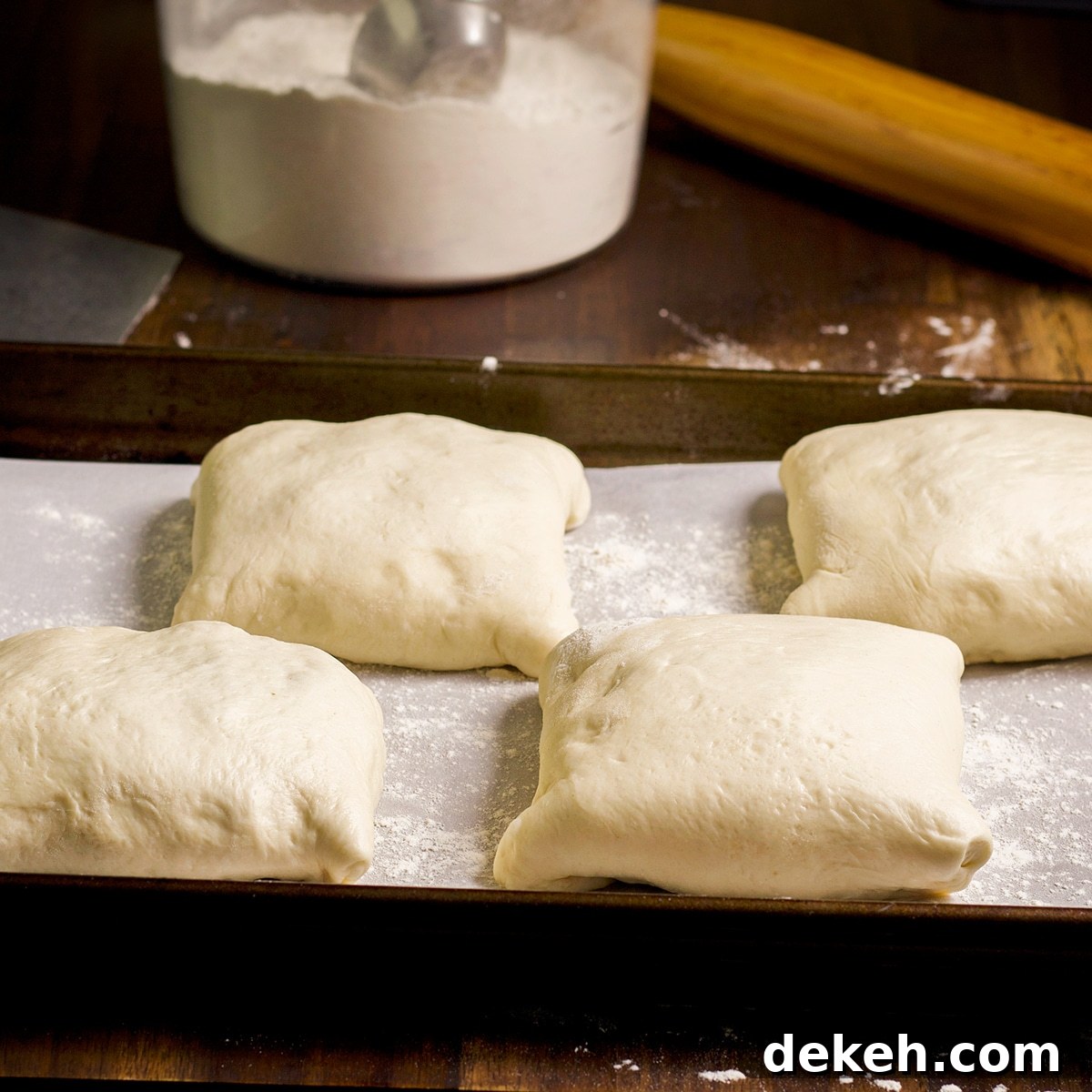 Kraut burgers on a baking sheet, resting to let the yeast dough rise before baking.