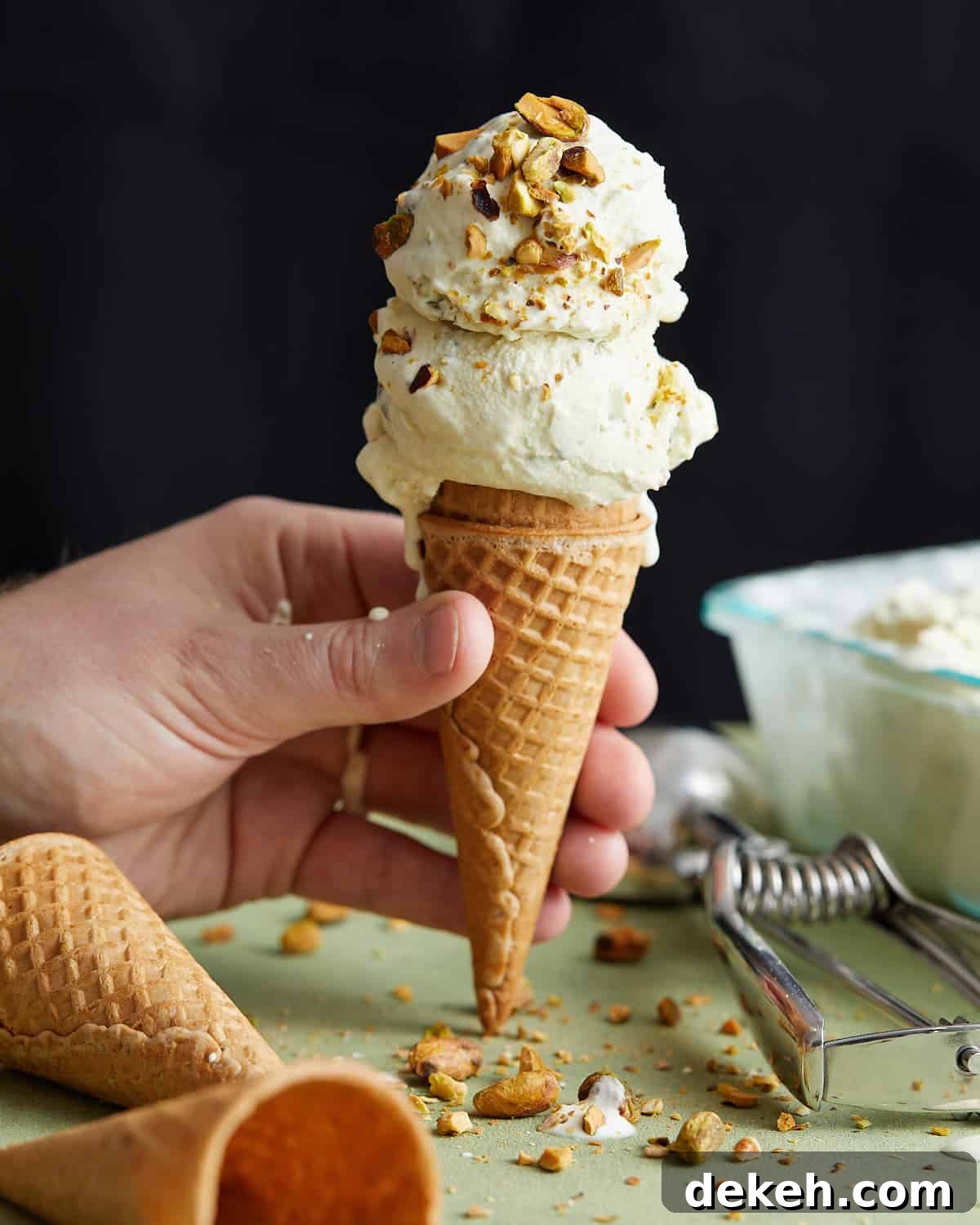 Up close photo of pistachio ice cream on a waffle cone.