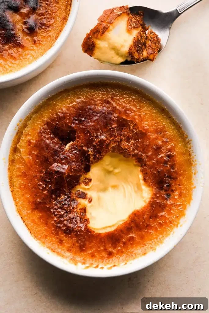Pumpkin creme brulee with a caramelized top, partially eaten to reveal the creamy pumpkin custard inside.