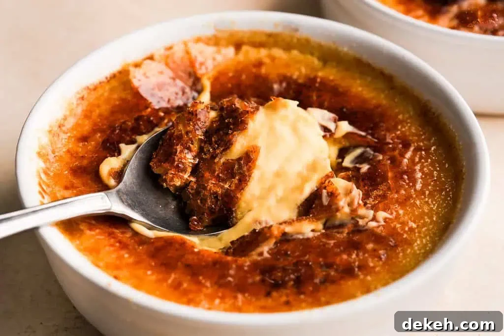 Pumpkin creme brulee with a caramelized top, showing a spoon lifting a portion of the smooth, spiced custard