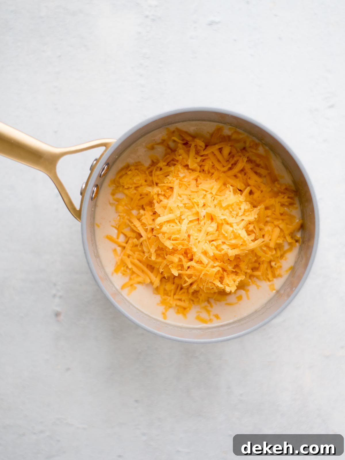 sharp cheddar cheese added to the saucepan
