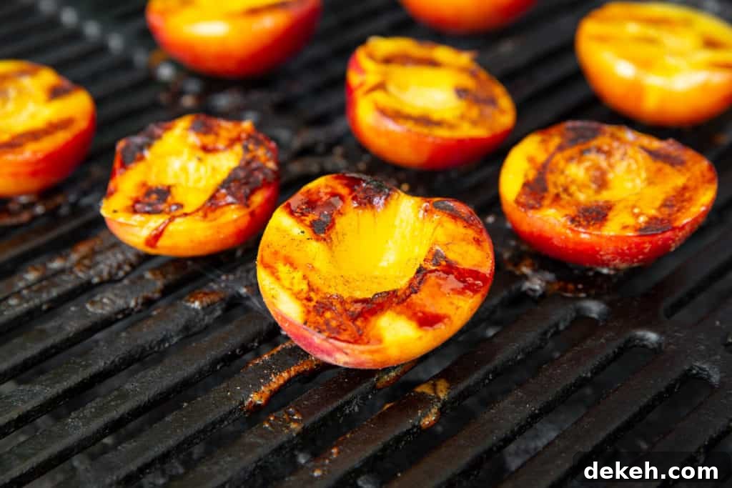 Close-up of grilled peaches on grill grates. 