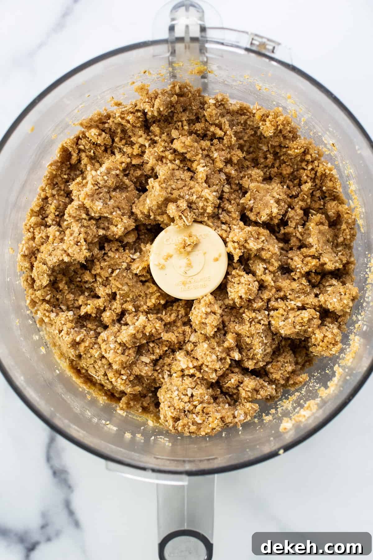 A food processor filled with oats and bananas.