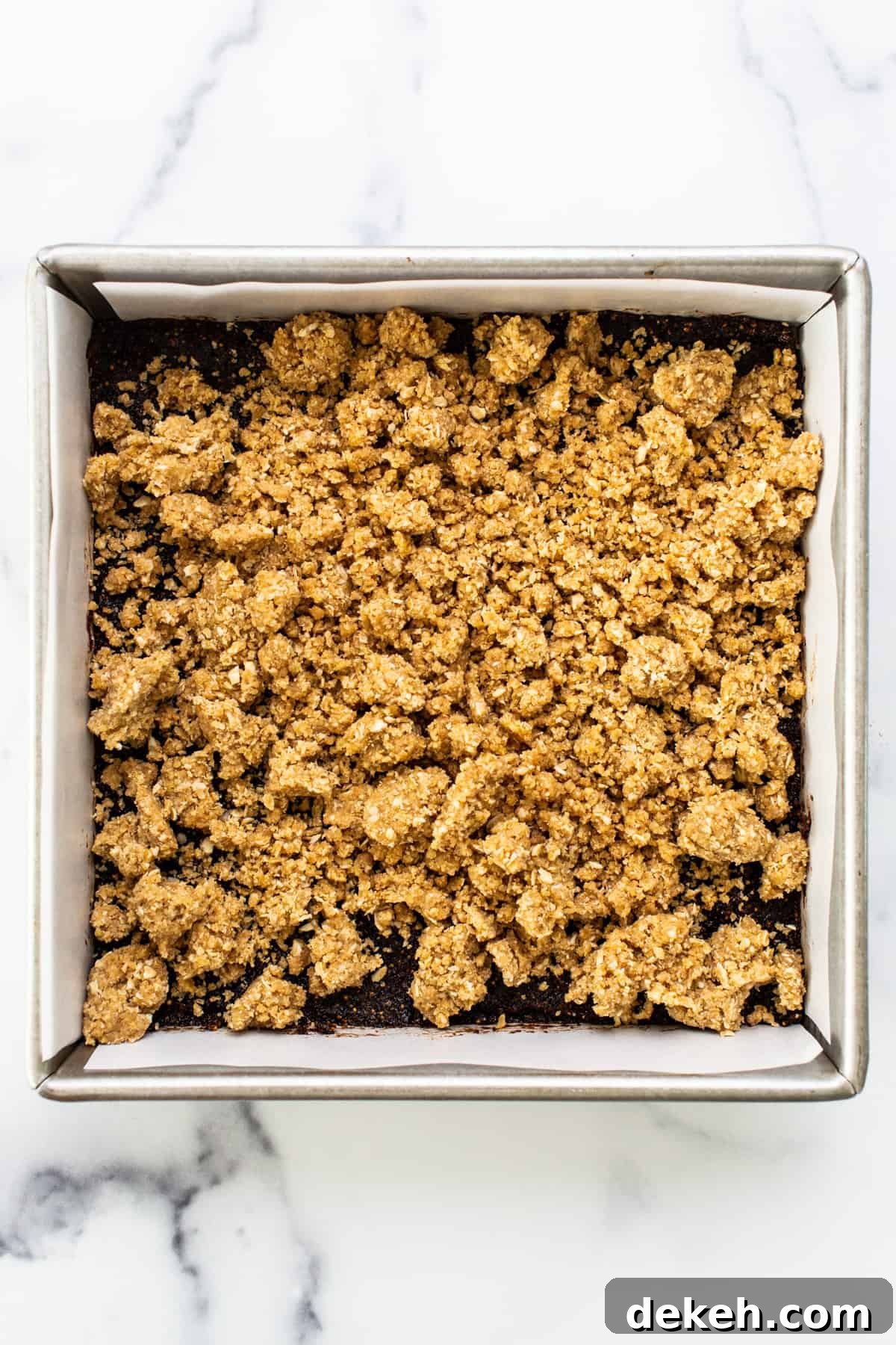 A baking pan with a layer of granola in it.