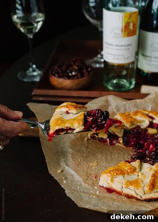 Removing a slice from a rustic cranberry galette.