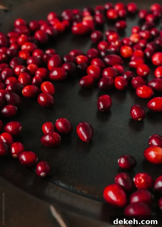 Cranberries on a dark surface.