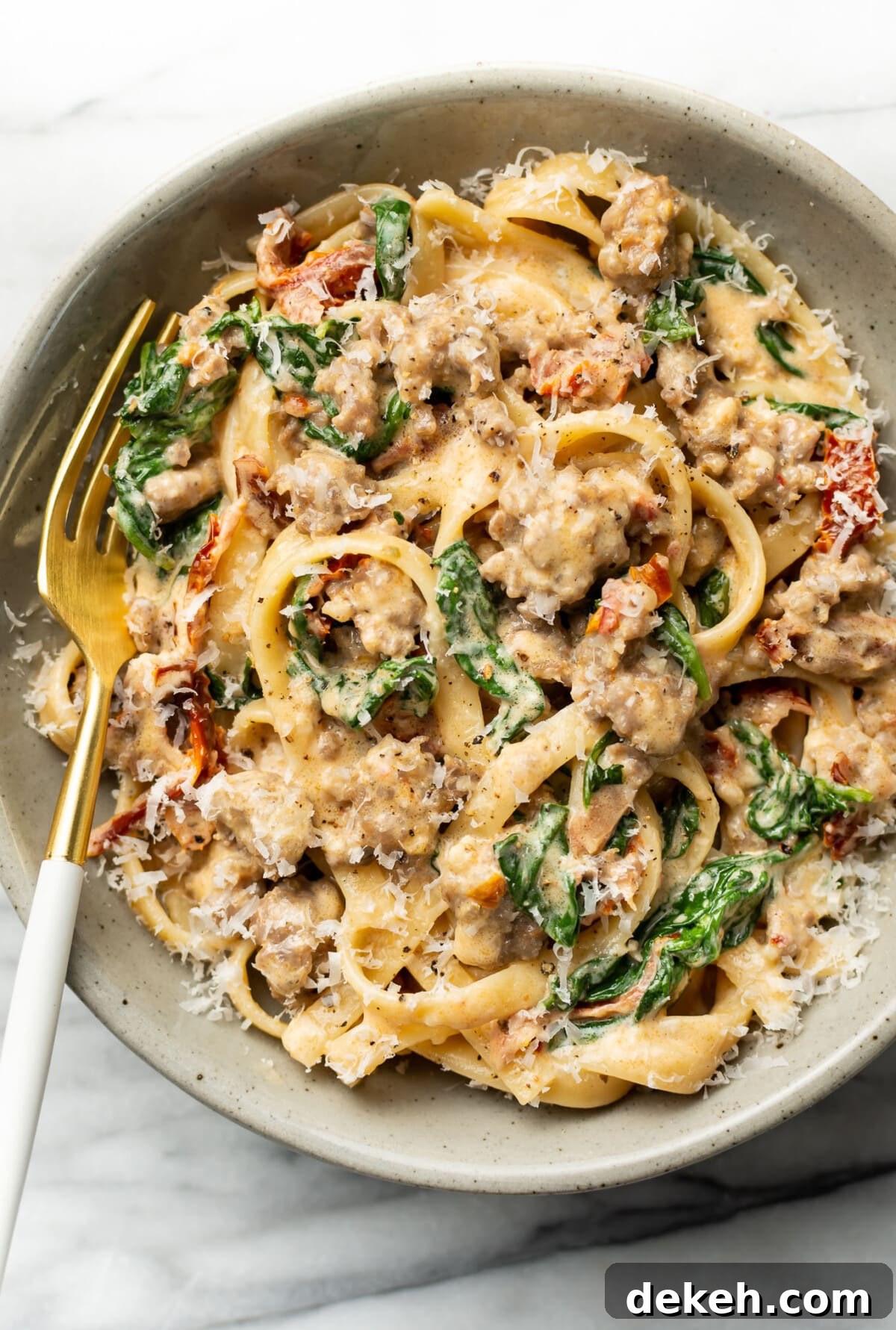a bowl of Tuscan sausage pasta with a fork