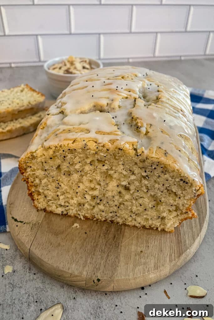 loaf of almond poppyseed bread showing the inside of the bread on a cutting board