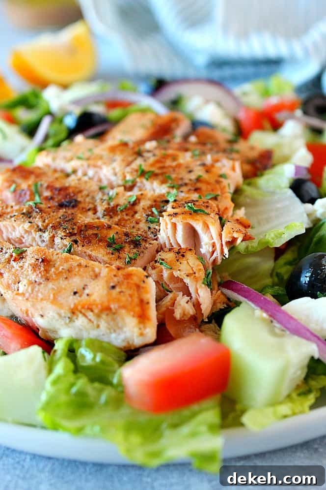 Side close up shot of Greek salmon salad on white plate.