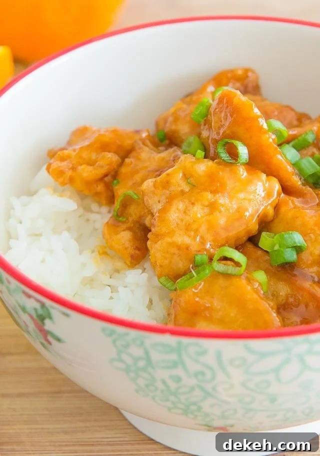 Orange Chicken - Garnished with Scallions in a Bowl with White Rice