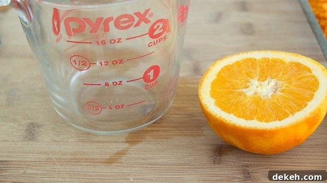Halved Orange and Measuring cup on Cutting Board