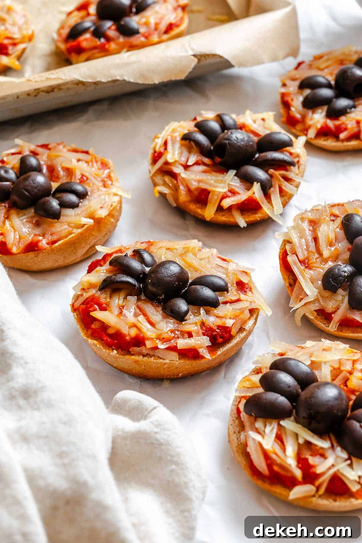 Completed Mini Spider Pizza [Bagel Bites] on a white surface.