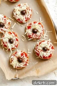 Process shots showing adding olives to mini spider pizzas.