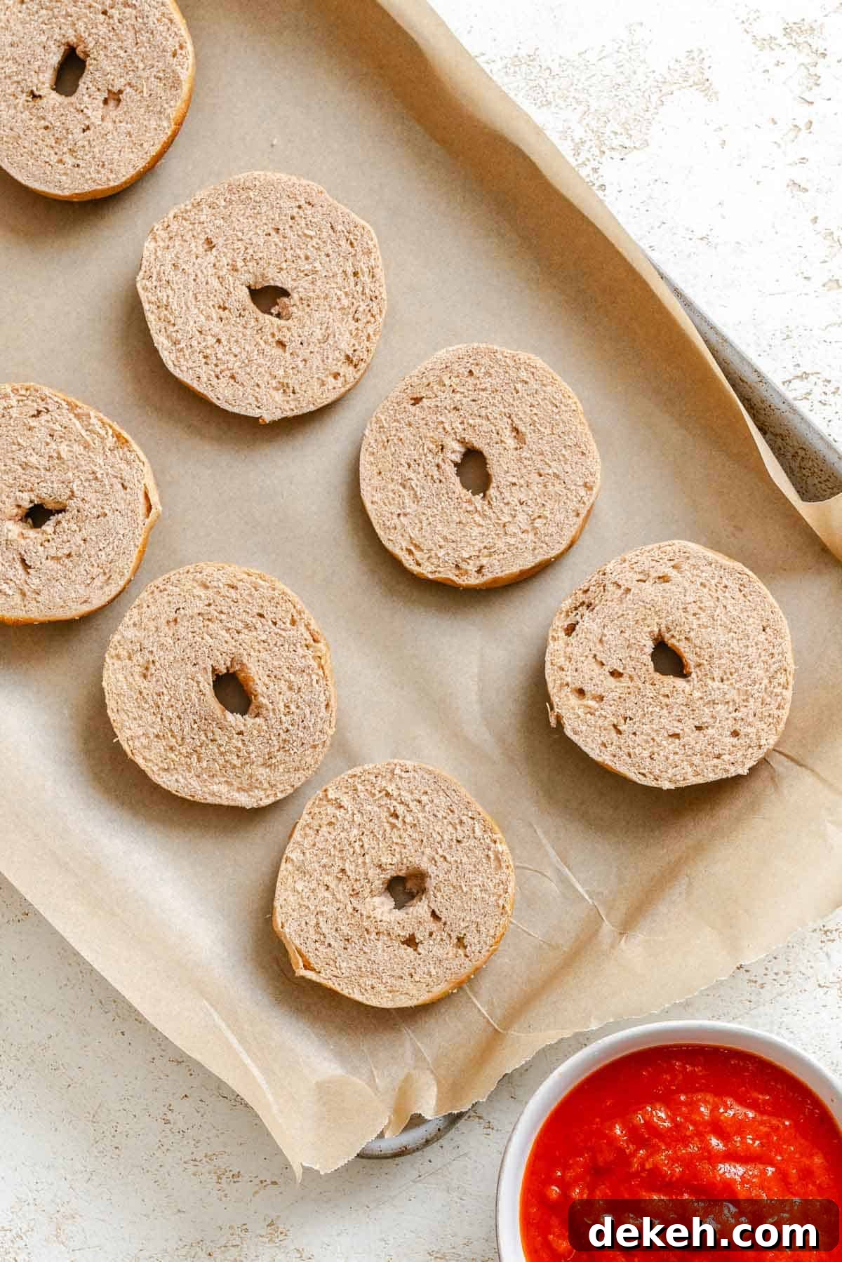 Process shot showing bagels on a baking tray.