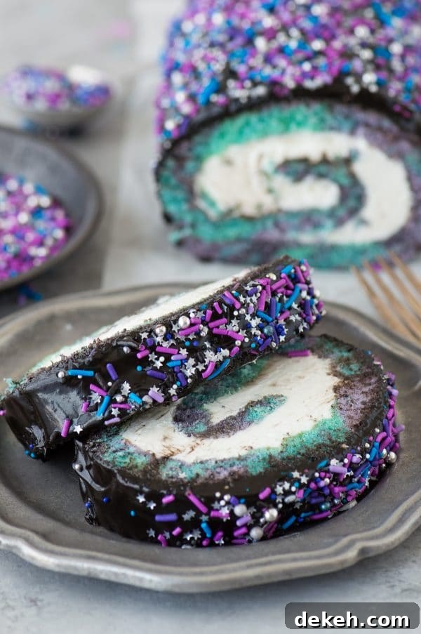 Multi-colored galaxy cake roll with black chocolate ganache, topped with sprinkles!