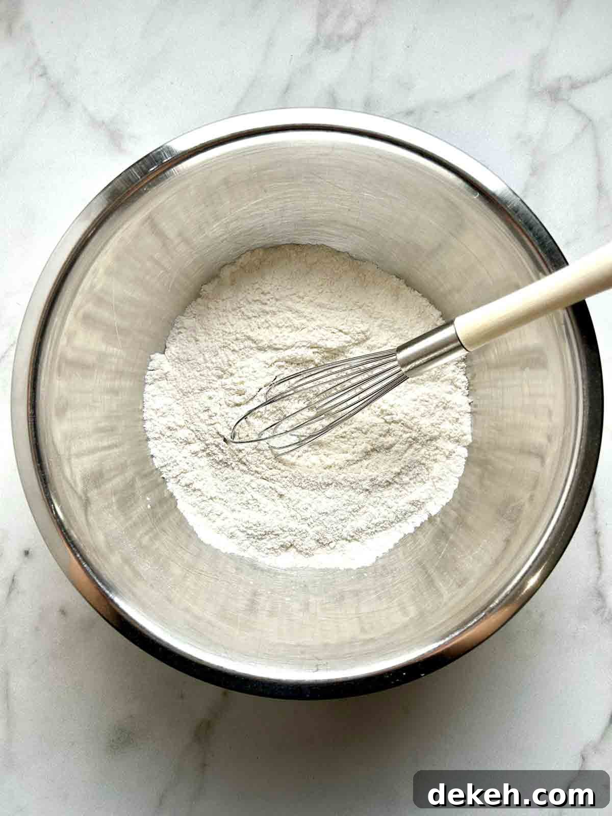 dry ingredients being whisked in bowl.