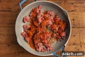 This is a picture of the ground beef in a skillet with taco seasoning.