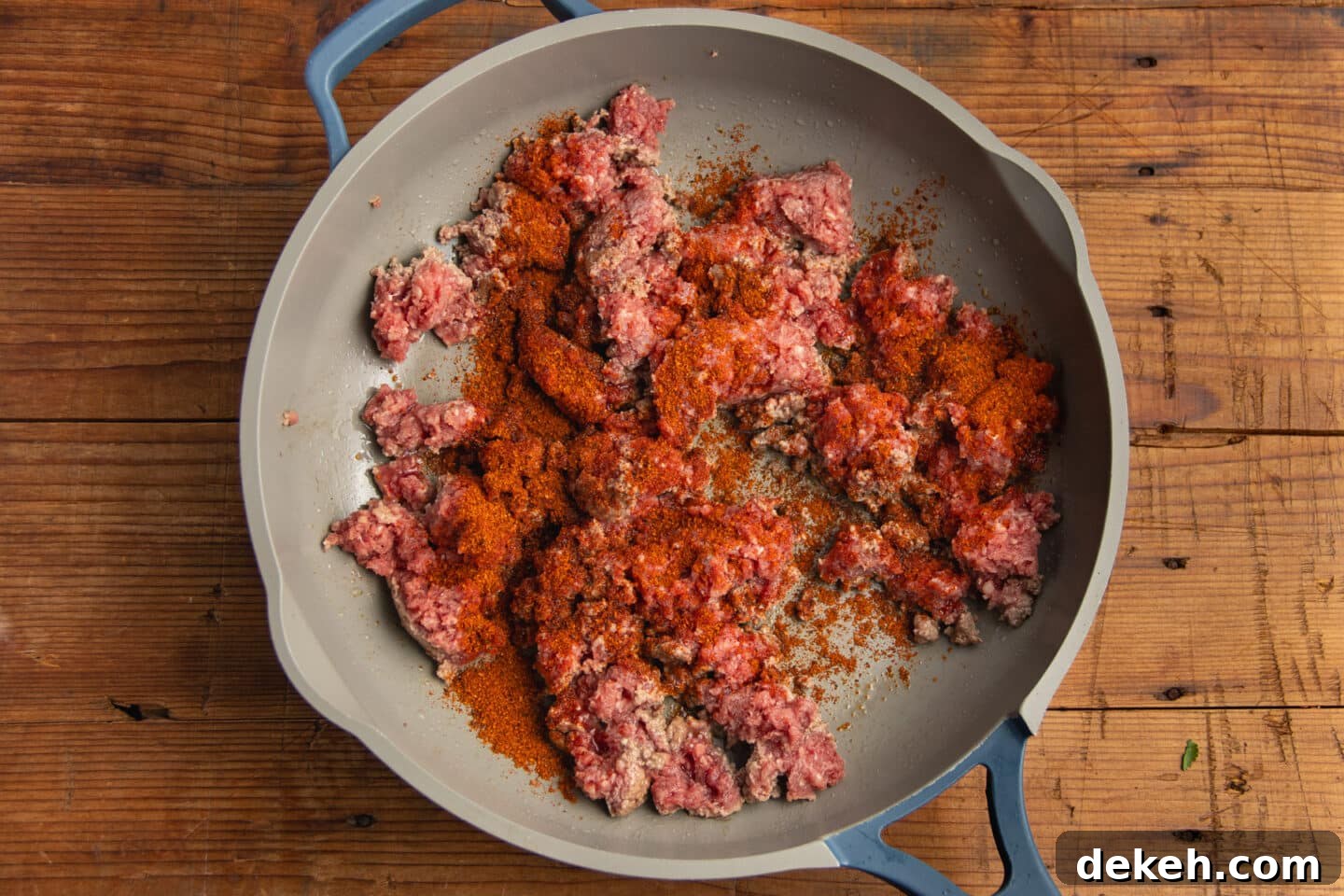 This is a picture of the ground beef in a skillet with taco seasoning.