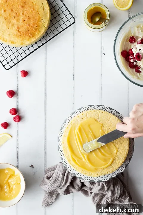 Lemon curd being spread onto cake.