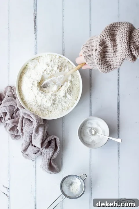 Someone mixing flour in a bowl with a wooden spoon