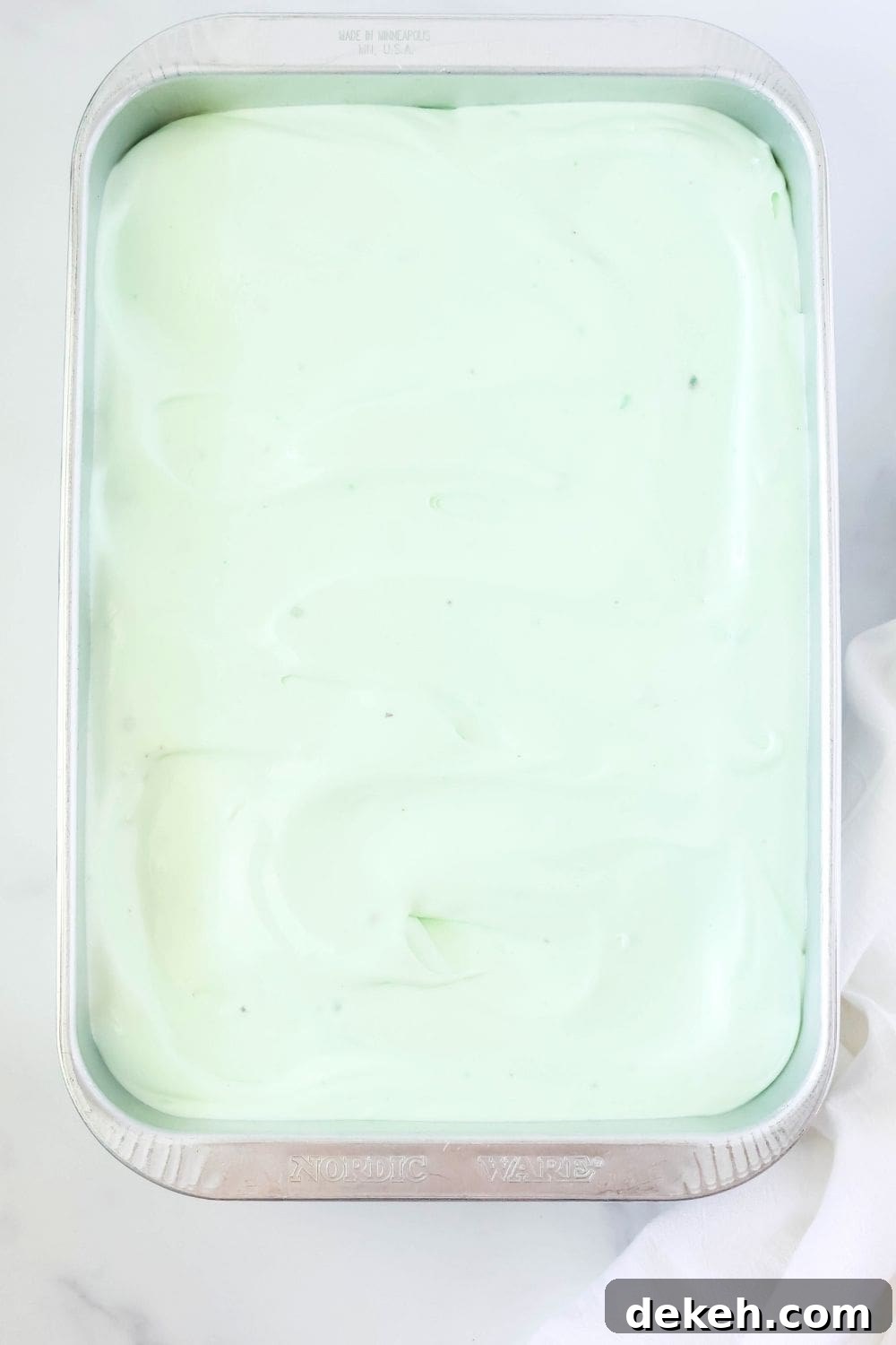 overhead view of a 9x13" cake pan, with pistachio and pineapple cake in it.