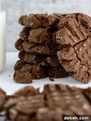cookies piled next to a jar of milk.