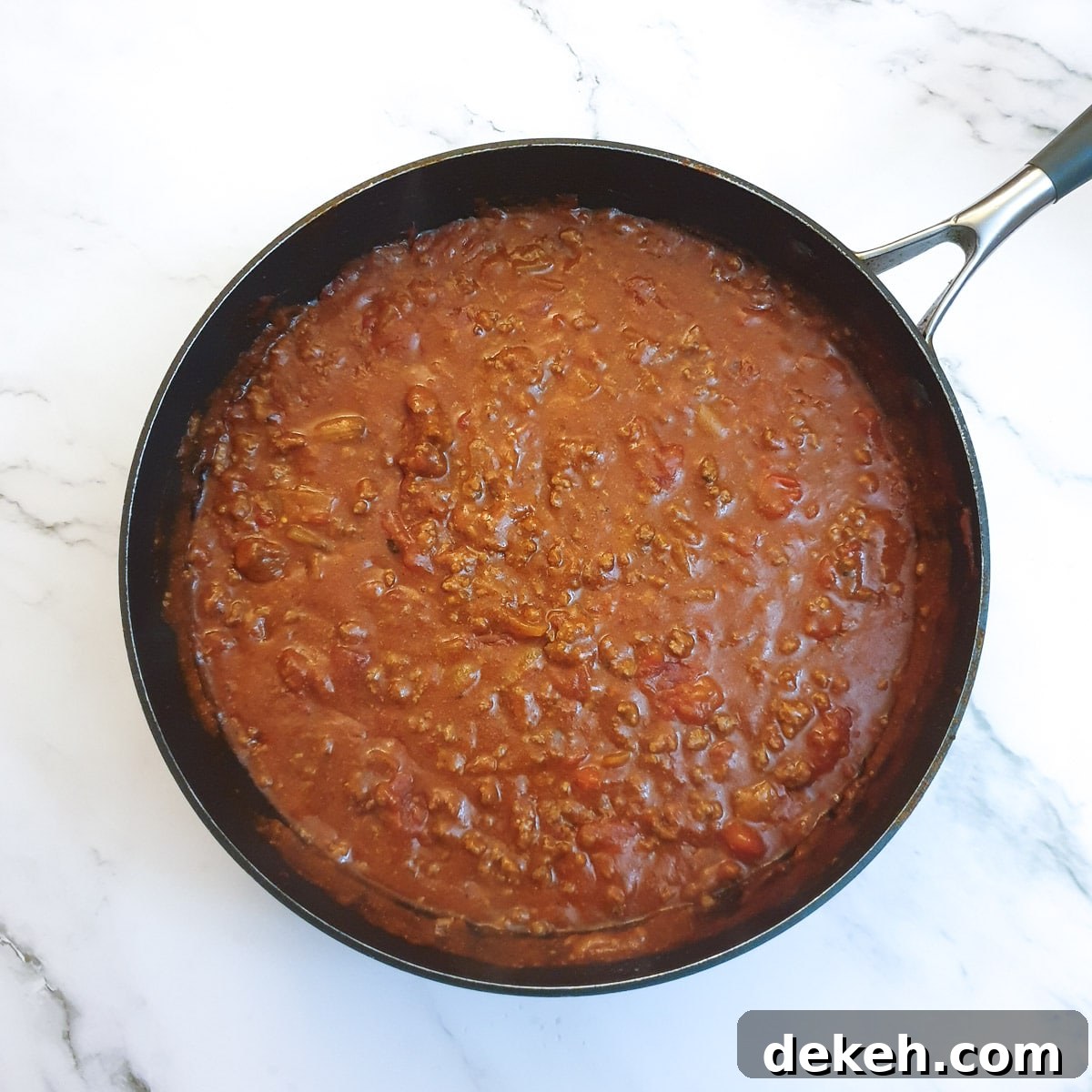 The thickened tex mex beef pie filling in a frying pan.
