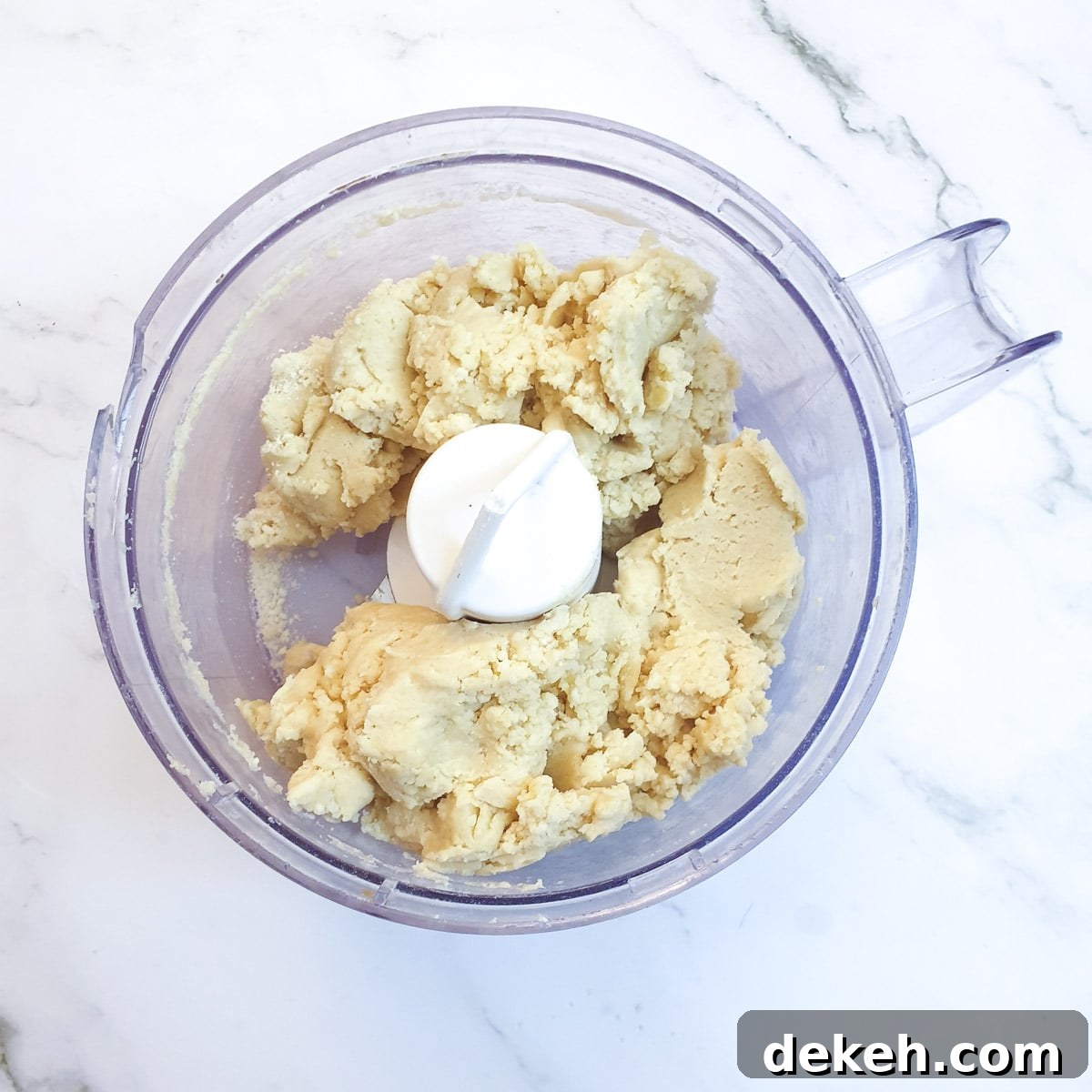 The cheesy pastry forming a ball in a food processor after the addition of water.