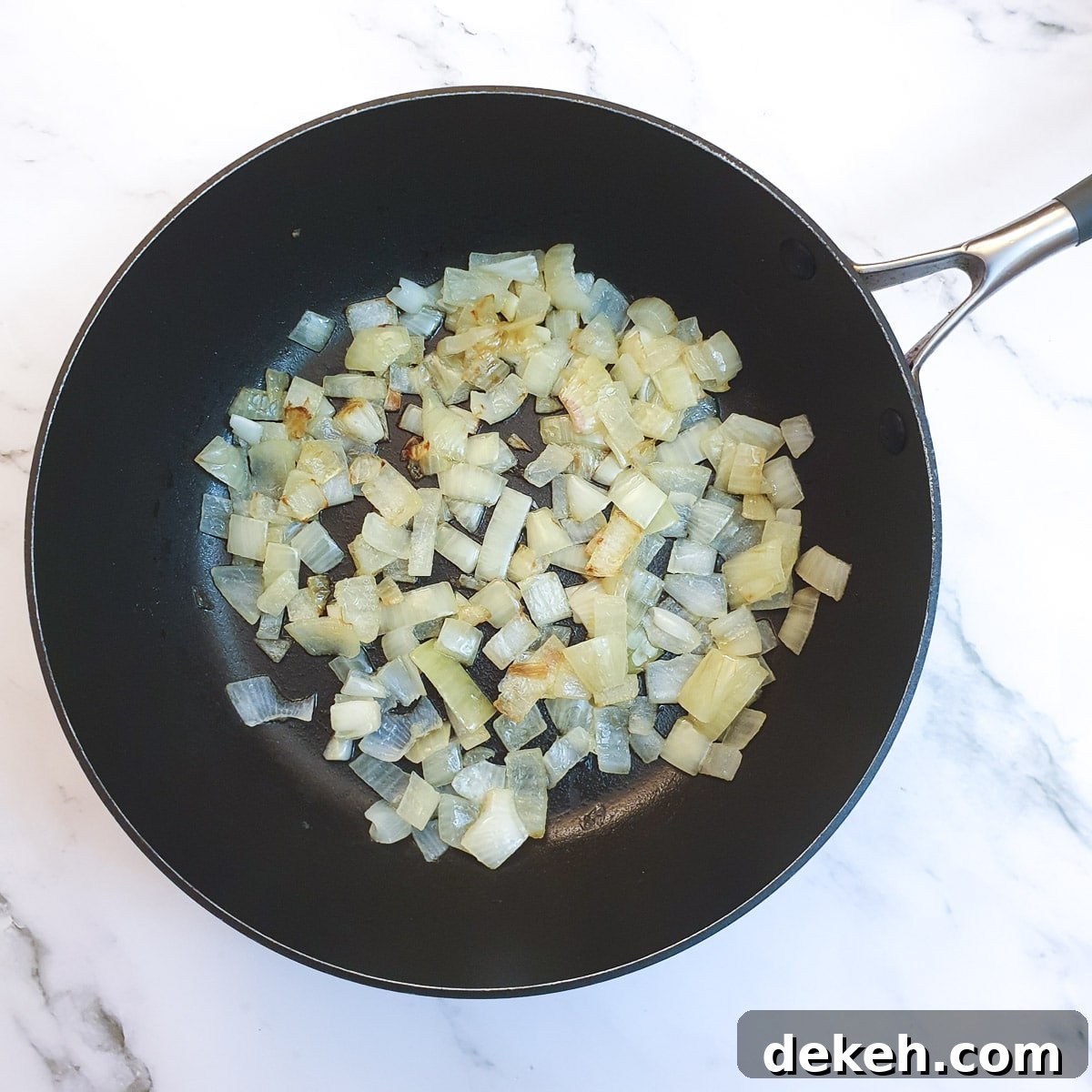 Chopped onions frying in a pan.